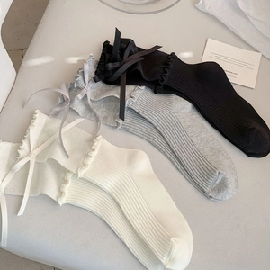 Detailed knit texture of ruffle trim calf socks with ribbon bows in three colors