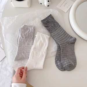 Close-up of breathable mesh knit texture and ribbed cuffs on gray mid-calf socks