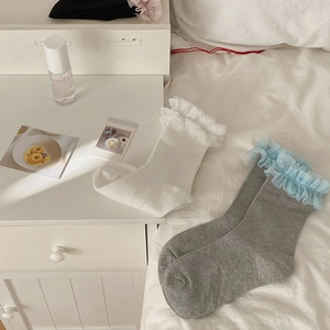 Détails de chaussettes blanches et grises avec poignets en dentelle de tulle