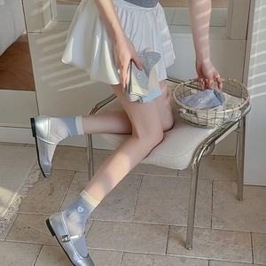 Detail of grey calf socks with heart embroidery, colorful ribbed cuffs and Mary Jane shoes