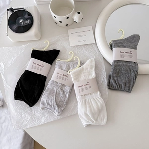 Flat lay of breathable gray and white mid-calf socks set with minimalist packaging