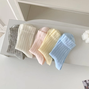 Close-up of five pairs of colorful ribbed cotton crew socks in soft pastel tones