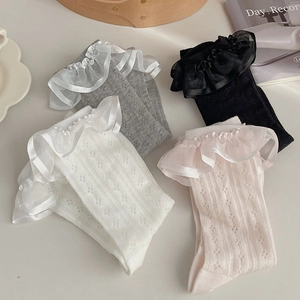 Détail de chaussettes à volants en dentelle en quatre couleurs avec maille ajourée douce