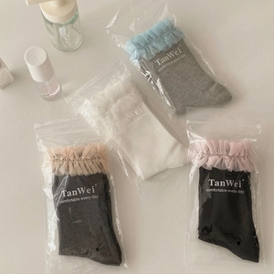 Détail des bords à volants en dentelle et tulle sur les chaussettes en maille mi-mollet