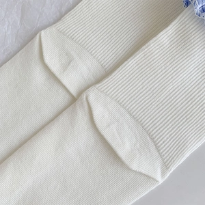 Detail of white ribbed knit cotton socks showing premium stitching and soft texture