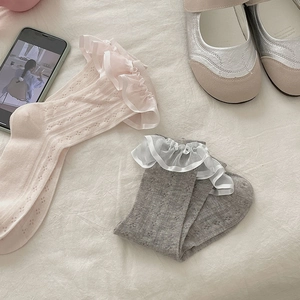 Gros plan de chaussettes Lolita en dentelle rose et grise avec bords à volants