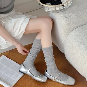 Japanese style grey slouch socks with rolled edges paired with silver Mary Jane shoes