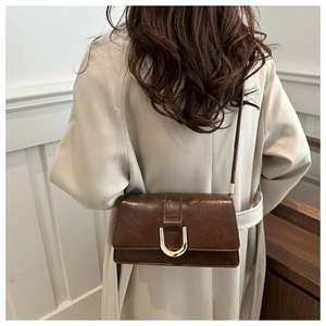 Detailed back view of a dark brown vintage crossbody bag with golden metal buckle clasp