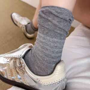 Close-up of gray ribbed slouch socks with mesh stitching and loose cuff style