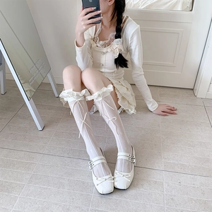 Detailansicht weißer Spitzenkniestrümpfe mit Satinschleifen und Herzmuster