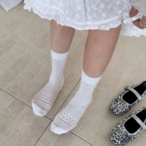 White hollow floral crew socks with sheer stripes, shown from top-down view on person