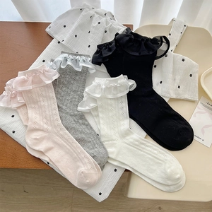 Detailed view of lace trim and diamond knit pattern on multiple colored cotton socks