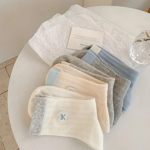 Detail of ribbed knit crew socks with delicate heart embroidery in soft pastel tones