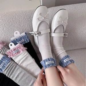 Detail of plaid ruffle socks with alphabet labels paired with white Mary Jane shoes