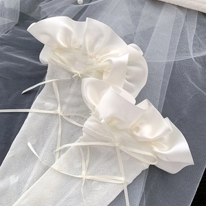 Detail weißer Netz-Spitzensocken mit Satin-Rüschenkante und zarten Schleifen