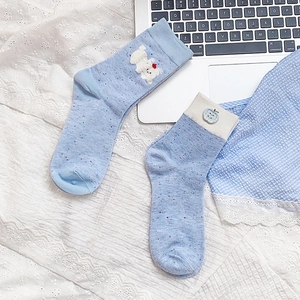 Detail of light blue crew socks with cute bear embroidery on white lace background