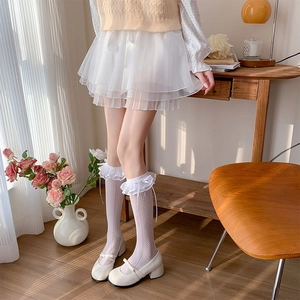 Detail of white double-layered lace trim calf socks with a sweet ribbon bow and Mary Janes
