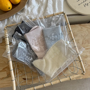 Five pairs of hollow floral crew socks in assorted neutral colors with zip packaging