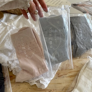 Close-up of cotton hollow flower socks in pastel colors with individual zip packaging