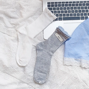 Close-up of ribbed cotton socks with delicate lace trim and vintage shell buttons