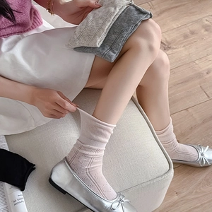 Detail of hollow jacquard knit socks in pink and beige with breathable cotton mesh texture