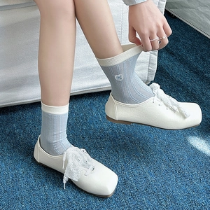 Close-up of light blue mesh socks with heart embroidery and lace trim shoes