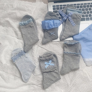 Detail of sweet bow tie socks with lace trim cuffs in light blue and grey tones