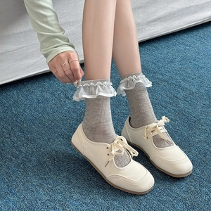 Light gray mid-calf socks with white translucent lace trim paired with Mary Jane shoes