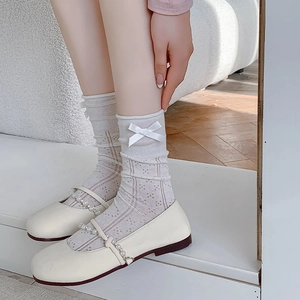 Close-up of white mesh bow socks paired with pearl-strap Mary Jane shoes in sweet style