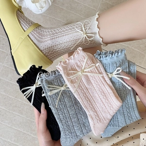 Détails de chaussettes JK avec nœuds en perles, bords à volants et maille ajourée en losange
