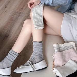 Detailed view of women's hollow jacquard mesh socks in gray, pink, white and beige