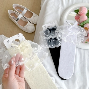 Detail of lace frill socks with polka dot mesh and bows in white, black and beige