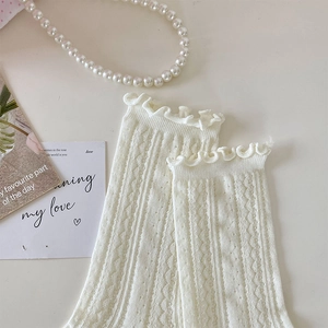 Detail of ruffled cuff and hollow-out knit pattern on cream white cotton socks