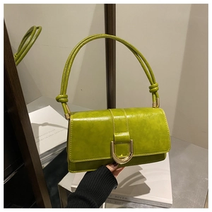 Detail of avocado green oil wax leather handbag featuring a gold D-buckle and knotted handle