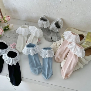 Detailed close-up of girls' Lolita socks with wide layered lace ruffles and floral embroidery