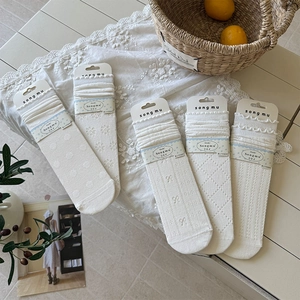 Detail showing five white mid-tube socks with various knit patterns and lace edges