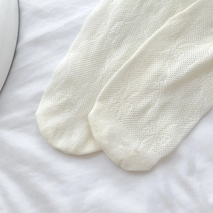Close-up of white lace mesh socks showing fine breathable knit texture and details