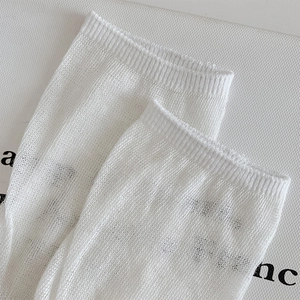 Close-up of white mesh knit socks with breathable texture and ribbed elastic cuffs