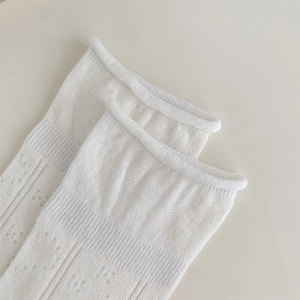 Macro detail of white hollow knit cotton socks with pointelle mesh and ribbed cuffs