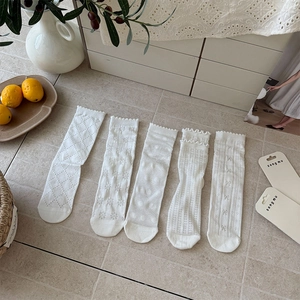 Detail of five white mesh lace crew socks with floral and polka dot hollow patterns