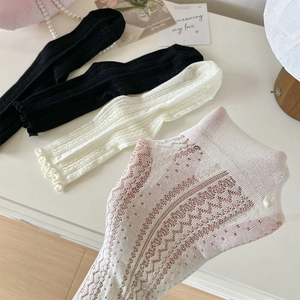 Detailed view of white lace hollow-out mesh socks with delicate wavy ruffled edges