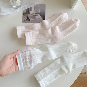 Detailed close-up of breathable hollow lace socks in white and pastel pink colors