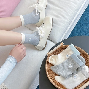 Detail of hollow bow embroidery and vertical ribbed texture on soft cotton socks