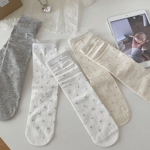 Close-up of ballet-style polka dot crew socks in grey and milk white colors