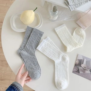 Detail shot of breathable hollow-out mesh socks in grey, white and beige colors