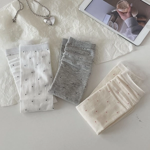 Three pairs of ballet-style dotted crew socks in white, grey, and beige with lace trim