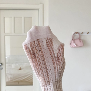 Gros plan de chaussettes en dentelle rose montrant l'élasticité et la maille respirante