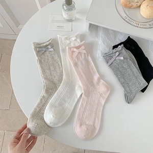 Detail of ballet style socks with silk bows and mesh patterns in multiple colors