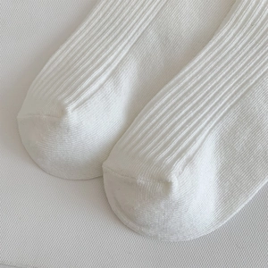 Detailed macro view of white ribbed knit fabric and flat toe seam on JK style socks