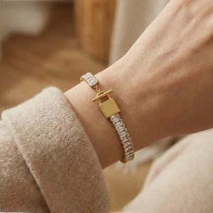 Detail of 18K gold-plated bracelet with baguette-cut zircons and T-bar lock closure